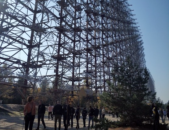 Group of people walking along a tall grid structure that is several stories high