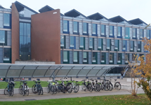 Three story building with many windows and bicycles parked in front