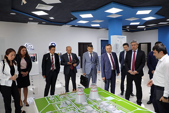 Group of professionals around a model of a nuclear facility