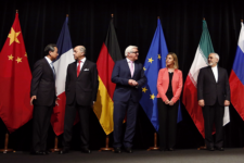 Government officials standing in front of their country's flags