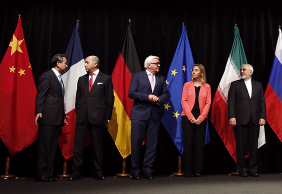 Government officials standing in front of their country's flags