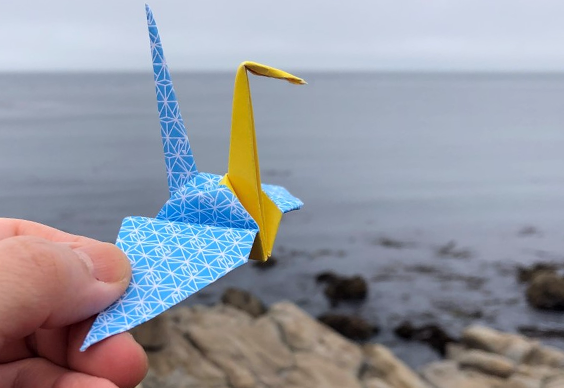 paper crane in front of the ocean