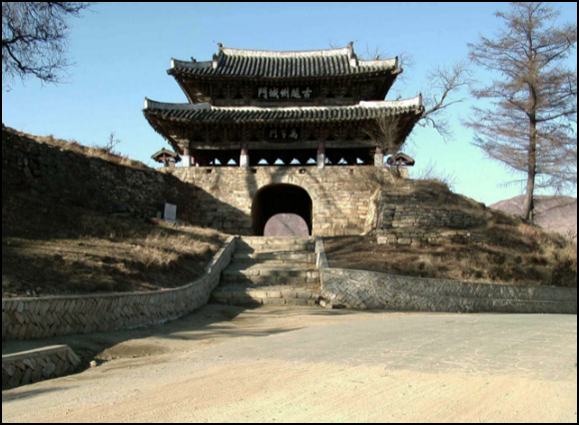 Pagoda-like building with two tier roof and masonry foundation with an arched entryway