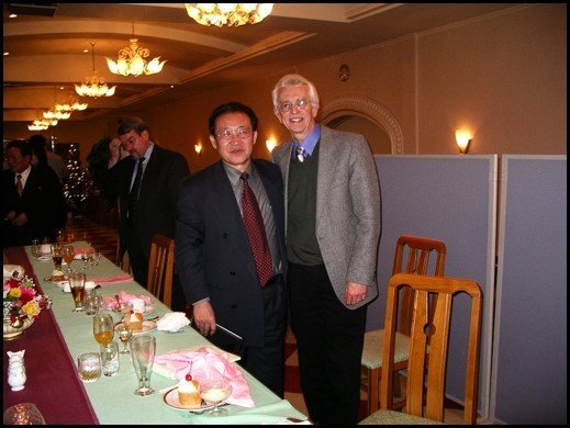 Hecker with North Korean official standing together in front of a dinner table