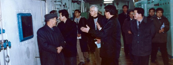 Hecker walking in an industrial facility with Korean tech specialists