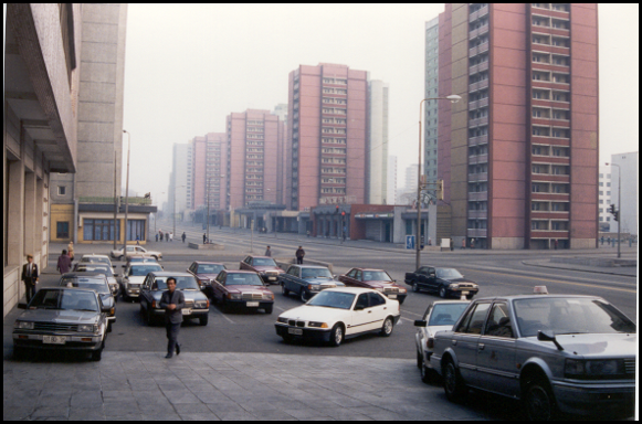 High rise buildings with some parked cars in the front