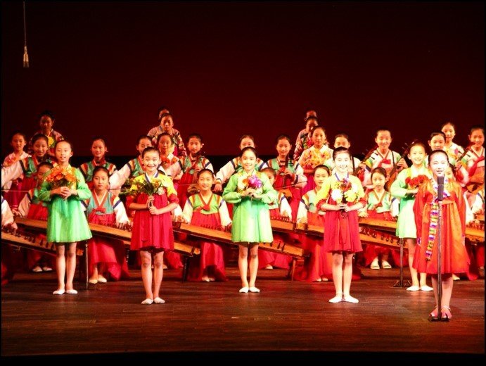 Bedecked girls in Korean traditional attire performing a dance on stage