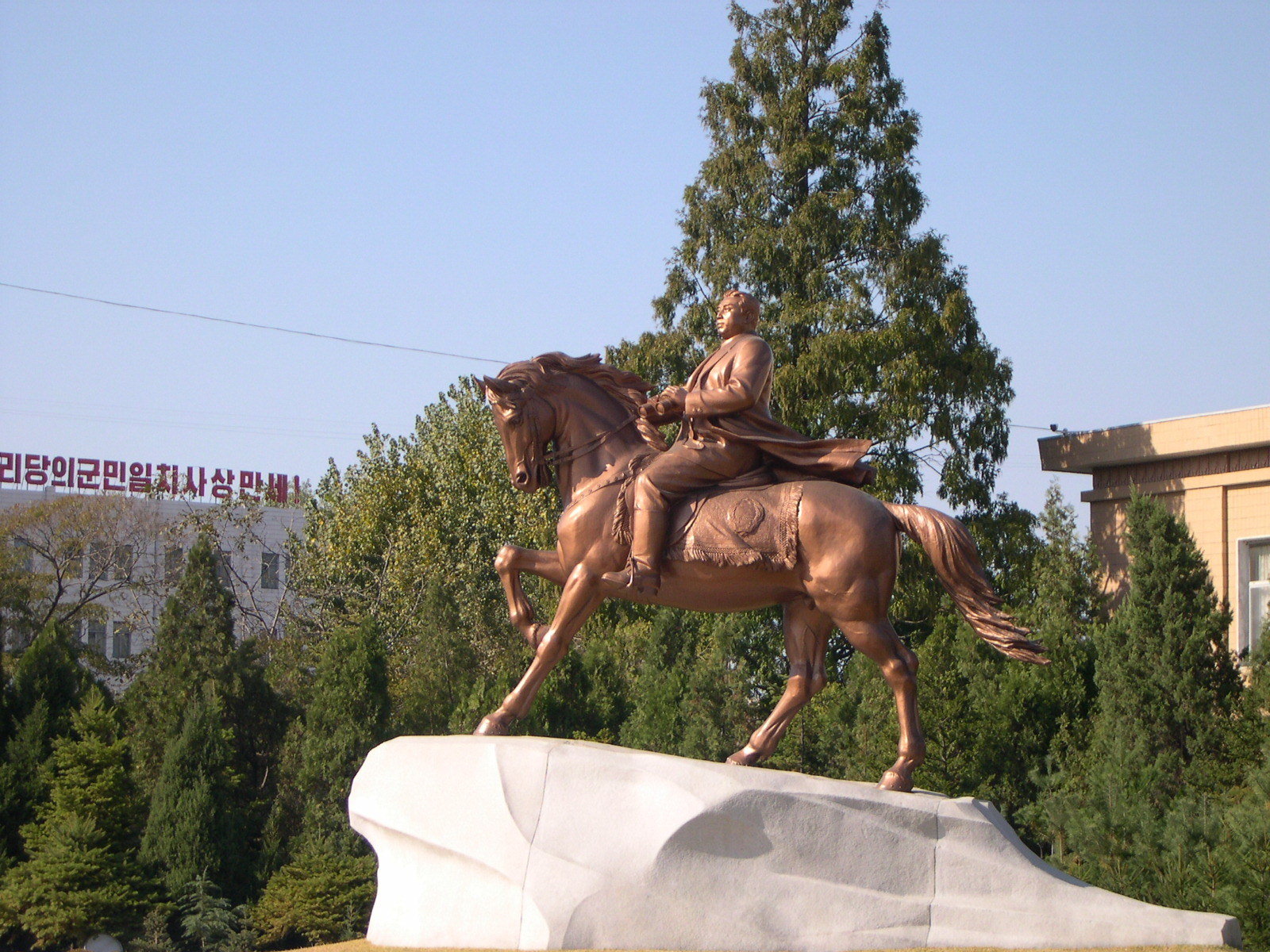 A bronze statue of a man riding a beautiful strong horse against the wind