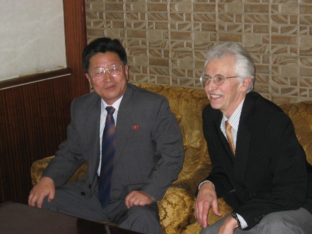 Two men in suits and ties seated next to each other