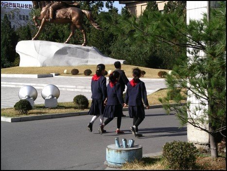 Three girls heading home from school seen from the back