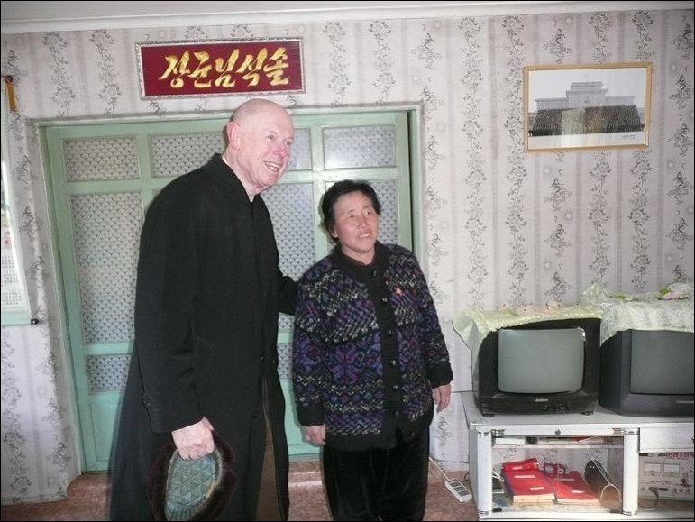 American (John Lewis) and a Korean woman looking at something out of the photo engaged in conversation