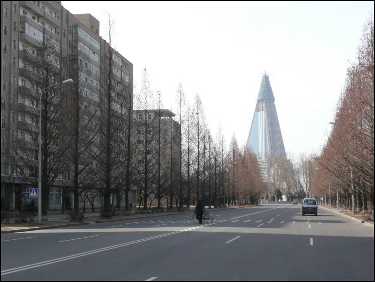 A giant pyramid-shaped high-rise tower still undergoing construction and dominating the view
