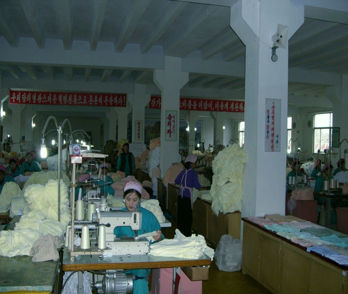 People working at small tables with sewing machines