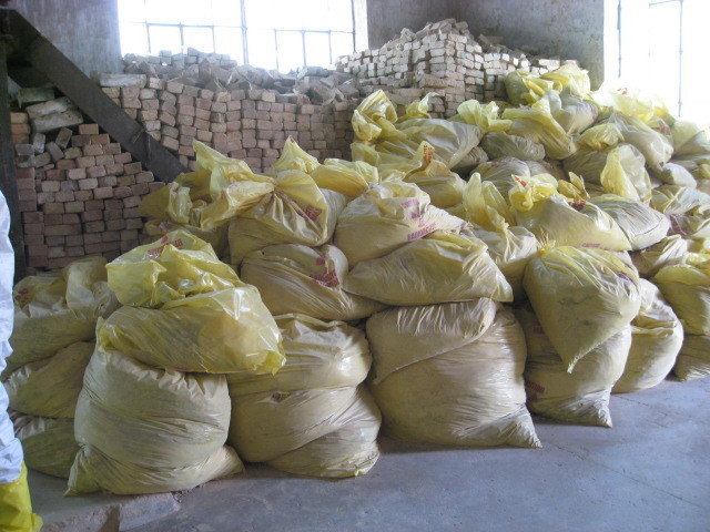 Heaped heavy plastic bags with sand and stocked bricks in the back