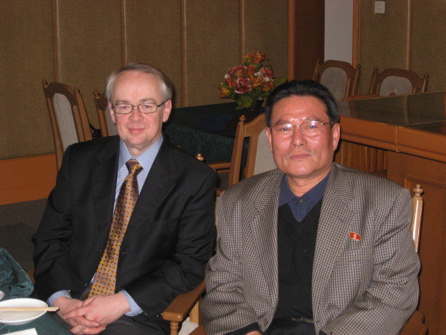 An American and a Korean posing for a photo seated next to each other
