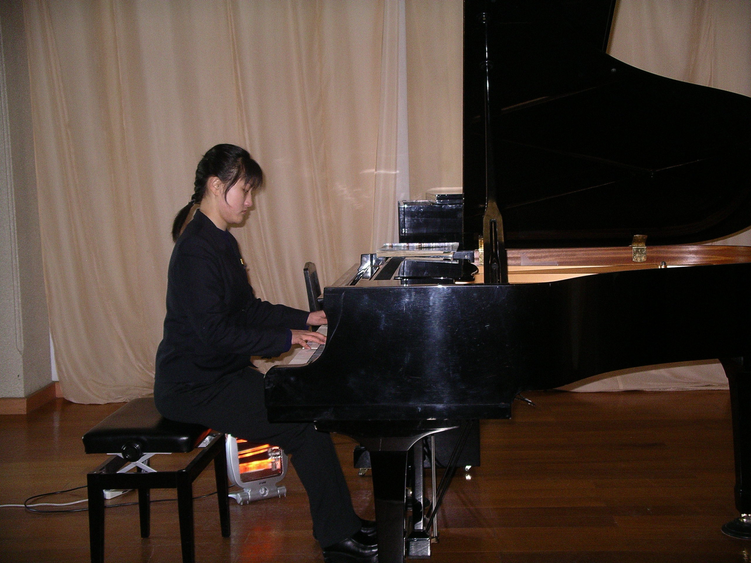 Girl playing a forte piano on stage