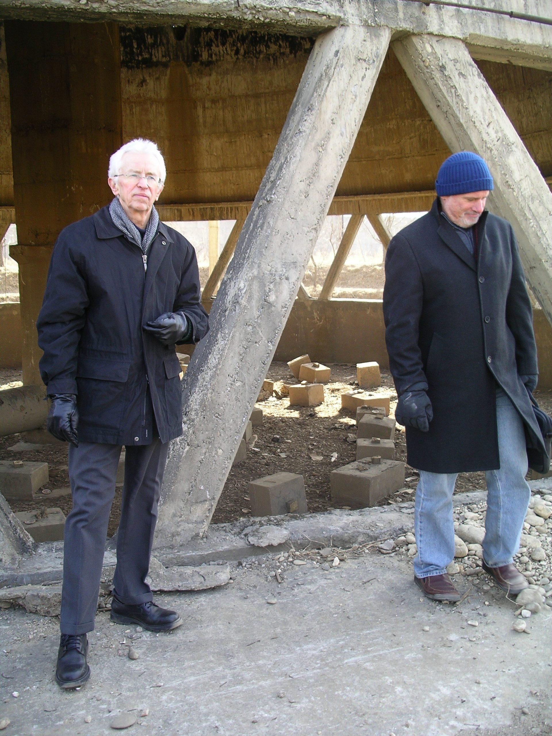 Two men in winter coats walking in the foundation of the cooling tower