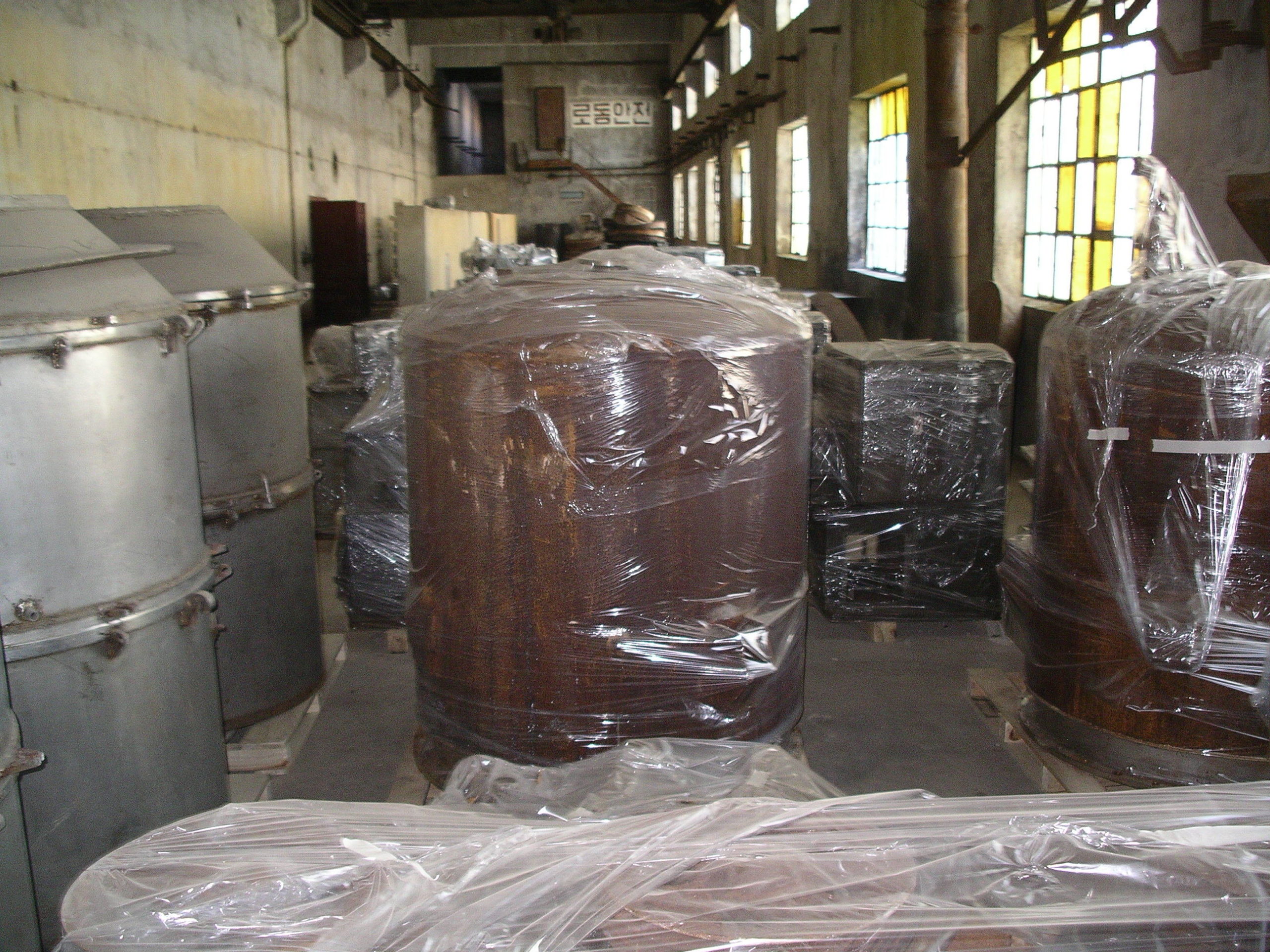 Metal tanks and other equipment pieces wrapped in plastic for storage