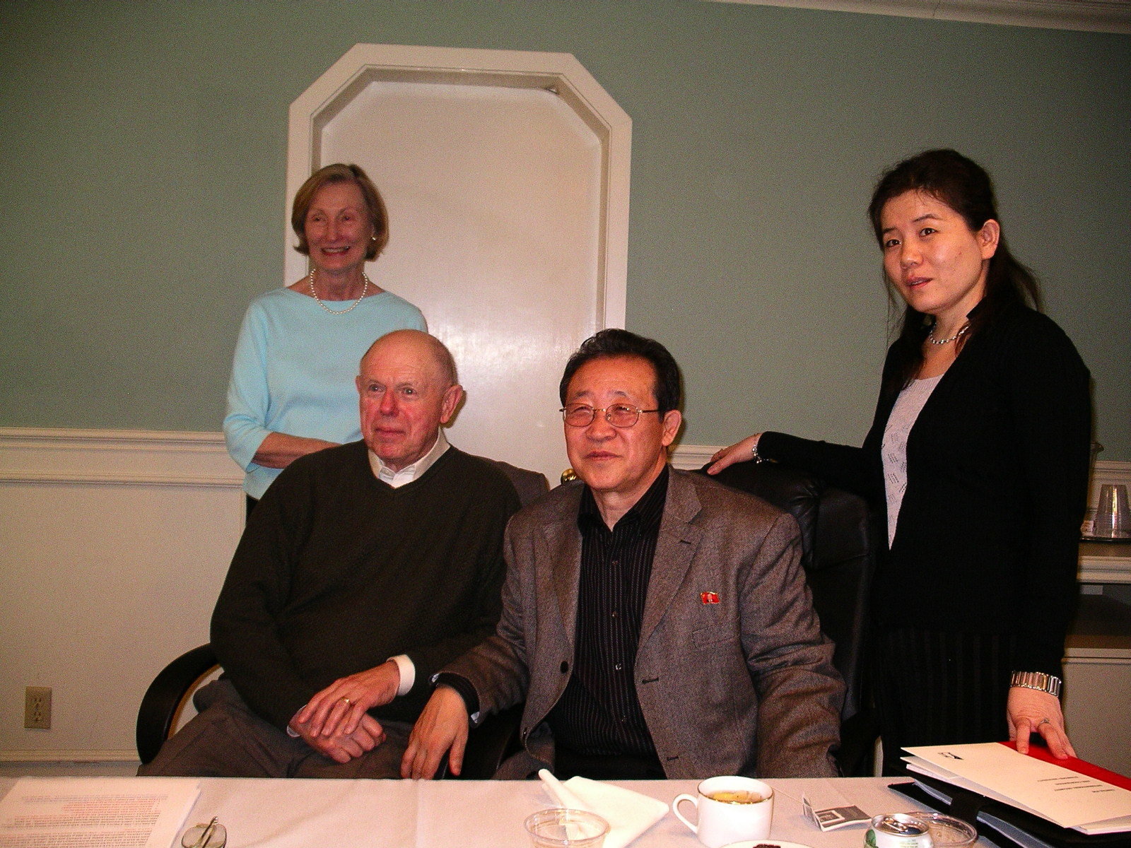 Two men sitting and two women standing on each side