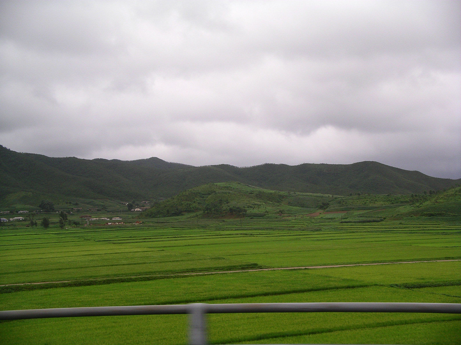 Green rain soaked field with hills in the background