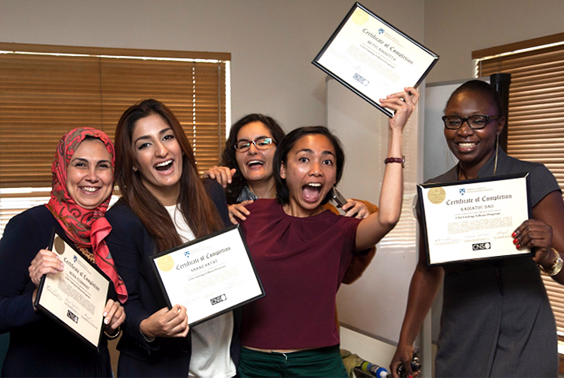 Five young ladies celebrating and holding up their certificates