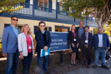 Leaders and participants in front of the CNS building and sign