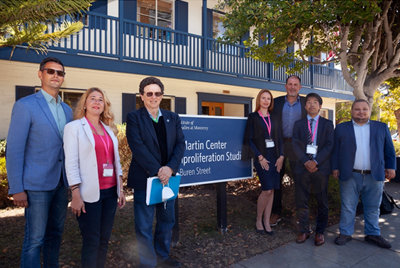 Leaders and participants in front of the CNS building and sign