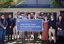 Group of participants and leaders standing outside around the CNS sign, smiling for the camera.