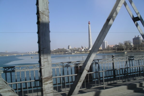 View from the bridge over a wide flowing river to a towering structure on the right bank