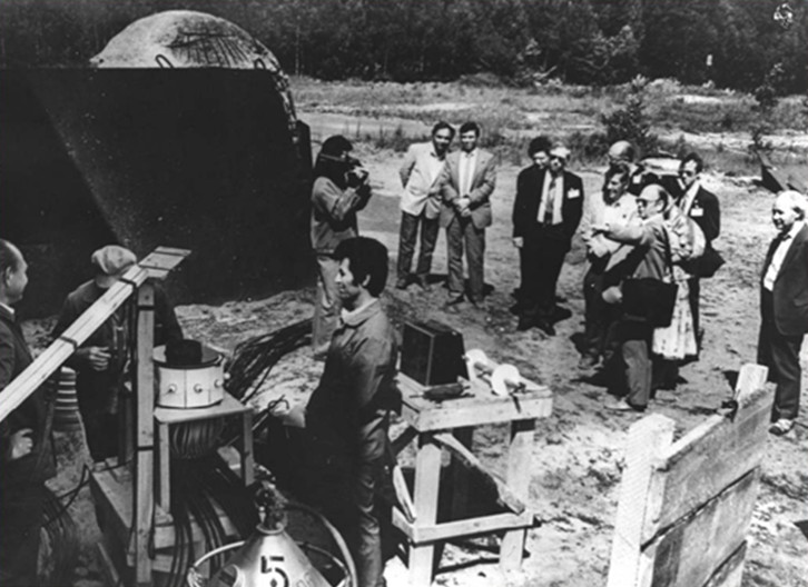 Group of scientists looking at machinery