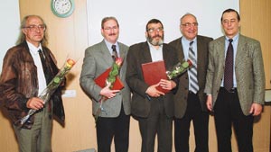 Group of men smiling for the camera, some with roses.