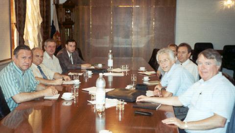 Group of men sitting around a conference table.