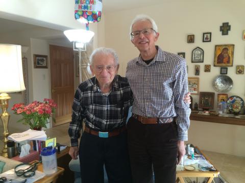 Two men standing smiling for the camera in a living room