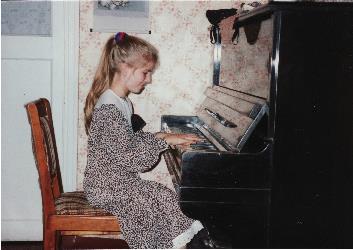 Little girl seated at a piano