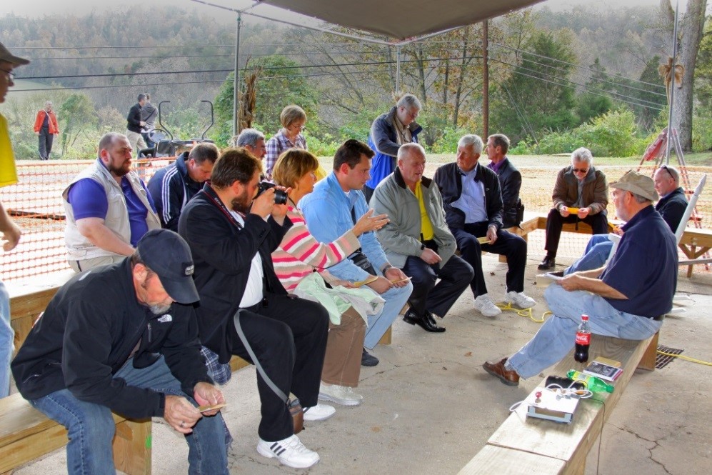 Group of people seated outside in discussion.