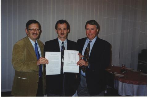 Three men standing for the photo holding papers