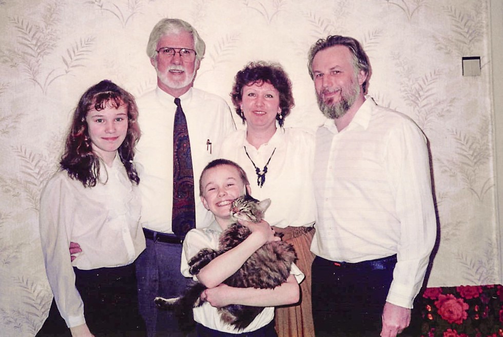 Family posing for the camera (Two men, a woman, a girl, and a little boy holding a cat)