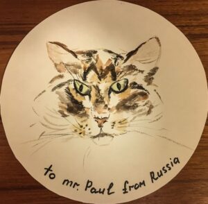 Painted face of a cat with the words To Mr. Paul from Russia, written at the bottom.