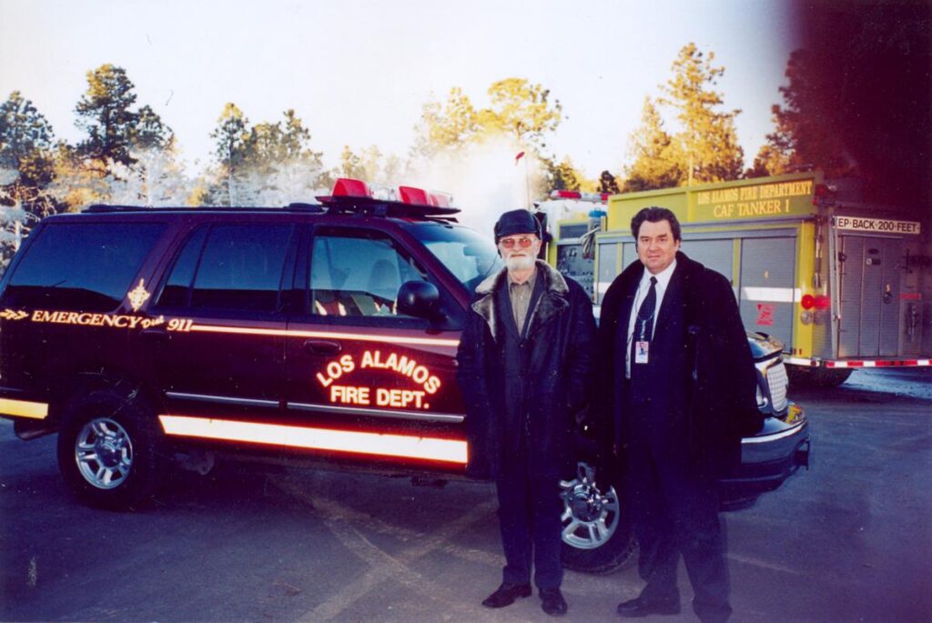 Two men in front of a fire SUV