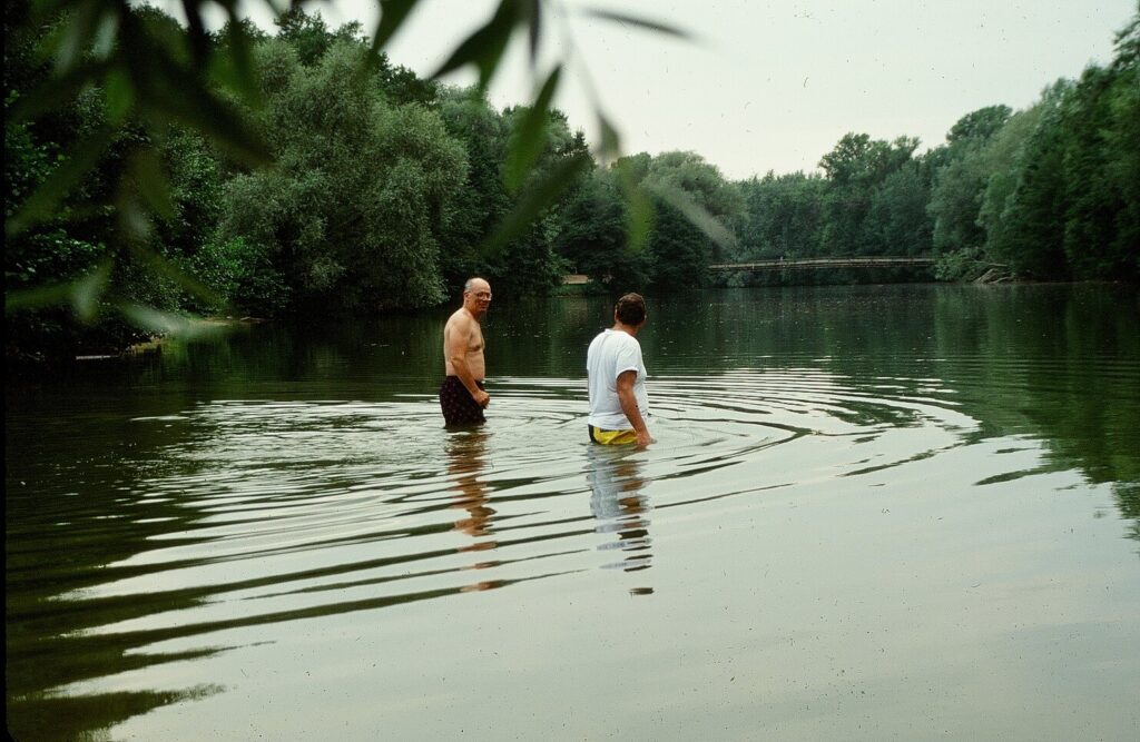 Two men standing in a body of water.
