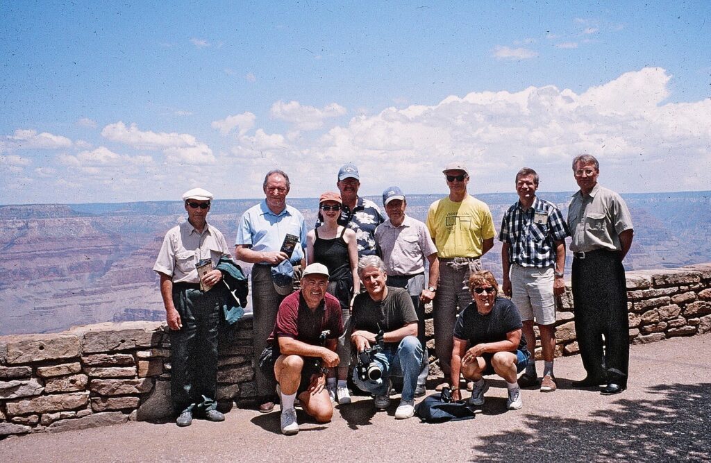 Group photo the with canyon behind them on a warm sunny day.
